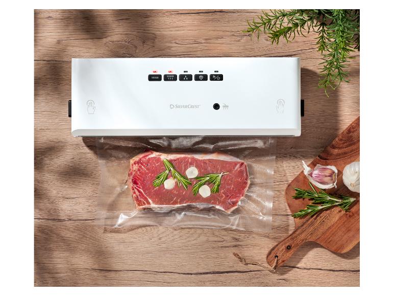 Zgrzewarka próżniowa SilverCrest ze stekiem, rozmarynem i czosnkiem na drewnianym stole.