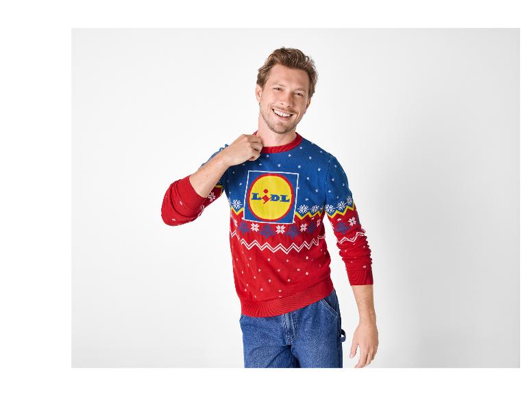 Mężczyzna w niebiesko-czerwonym świątecznym swetrze Lidl i dżinsach.