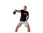 Mężczyzna ćwiczący z kettlebell, w koszulce i szortach.