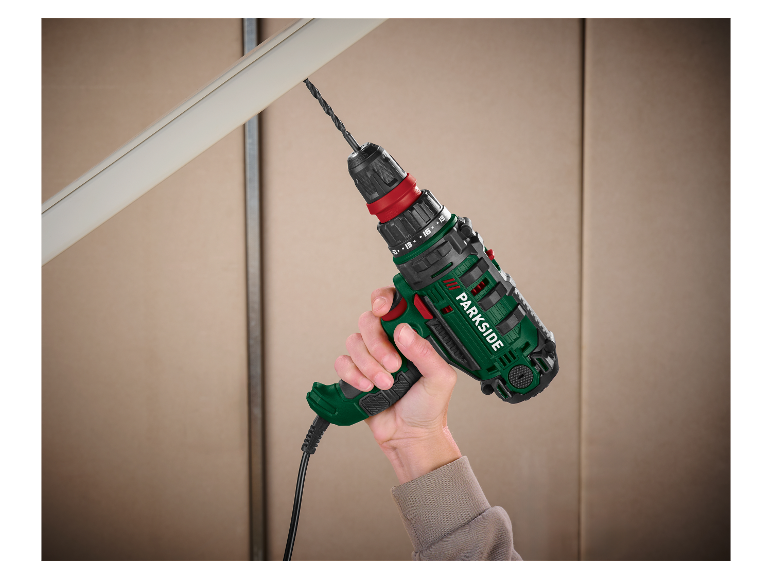 Ręka trzymająca wiertarkę Parkside, wiercącą w plastiku.