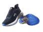 Para granatowo-białych butów sportowych z niebieskimi podeszwami, jeden stoi, drugi leży na boku.