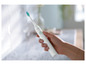 Ręka trzyma elektryczną szczoteczkę do zębów Philips Sonicare.