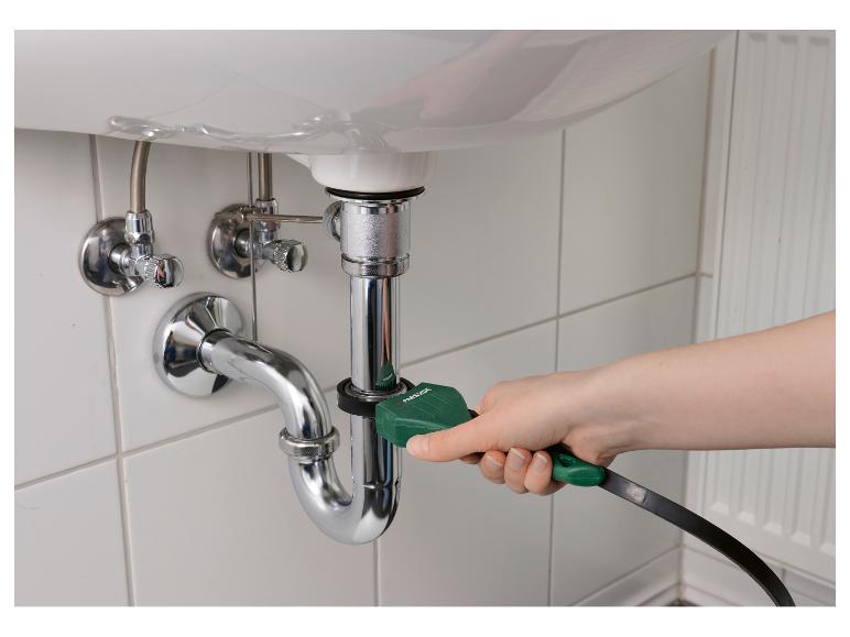 Ręka używająca narzędzia do czyszczenia odpływów Parkside na rurze zlewu.