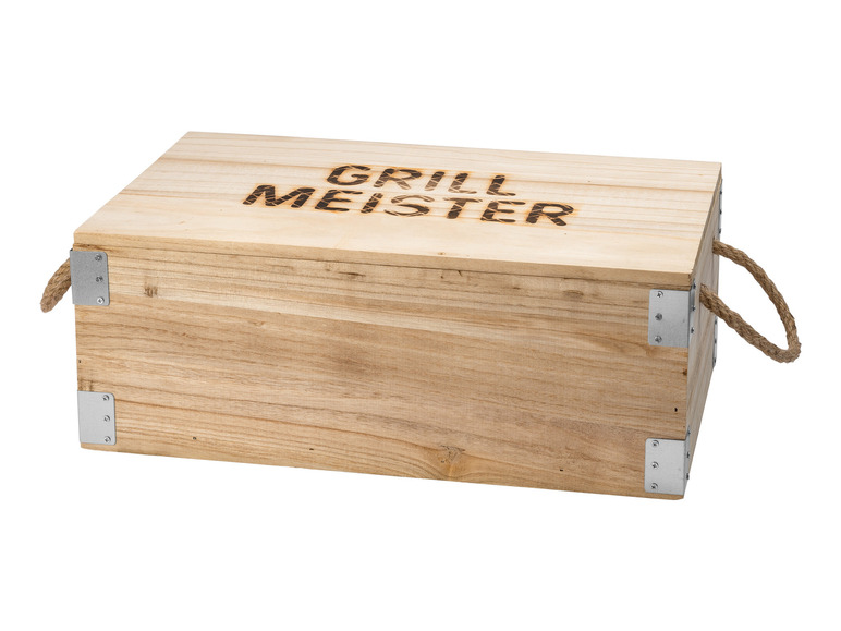 Drewniana skrzynia z napisem 'Grill Meister', metalowymi narożnikami i sznurkowymi uchwytami.
