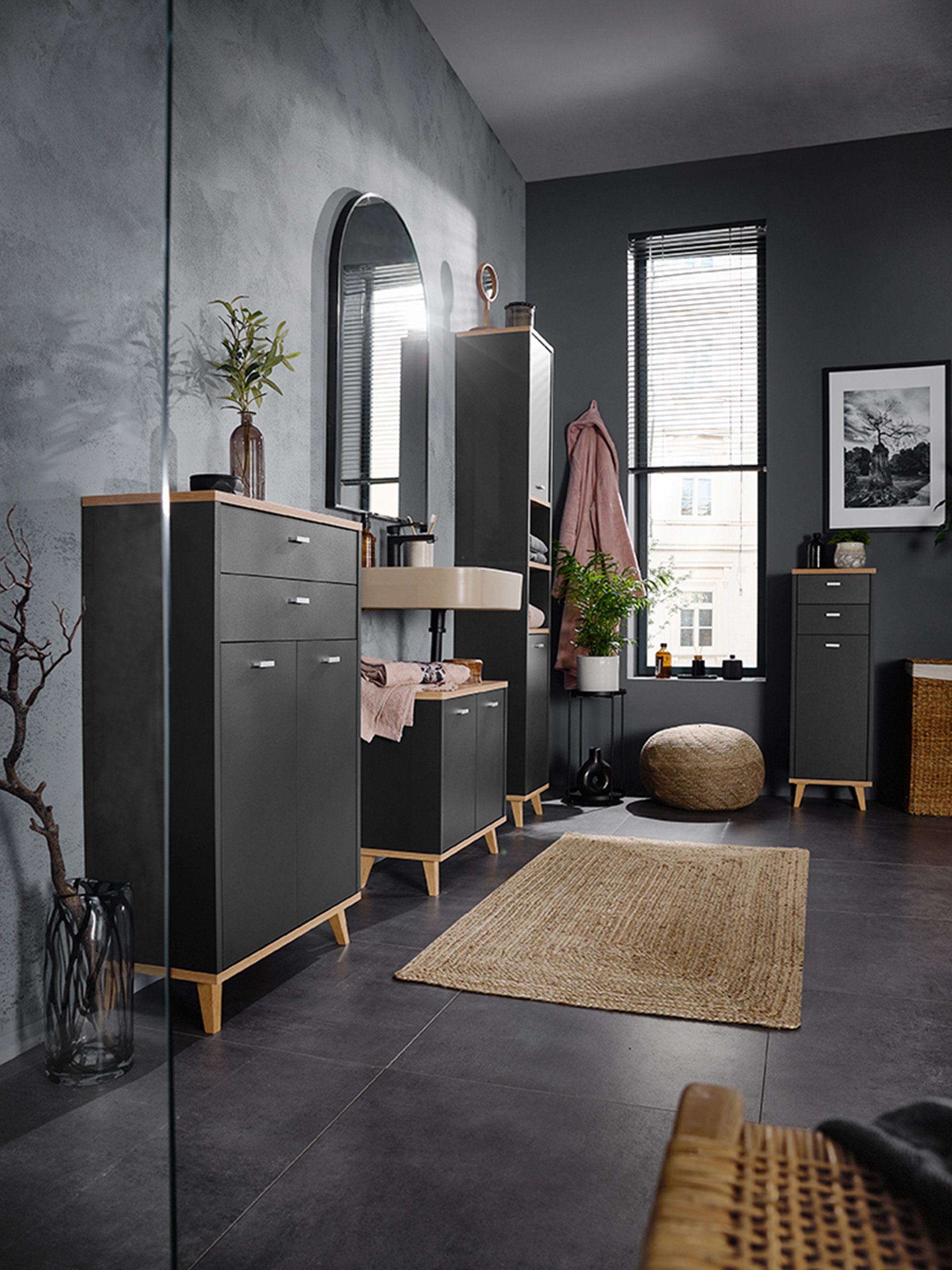 Łazienka z ciemnoszarymi szafkami, drewnianymi detalami i umywalką ścienną.