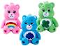 Trzy pluszowe misie Care Bears: różowy, niebieski i zielony, z charakterystycznymi znaczkami na brzuchu.