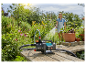 Pompa wodna Gardena i wąż ogrodowy w ogrodzie.