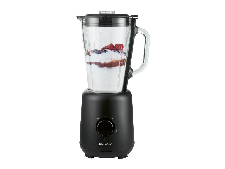 Czarny blender ze szklanym dzbankiem wypełnionym owocami i jogurtem.