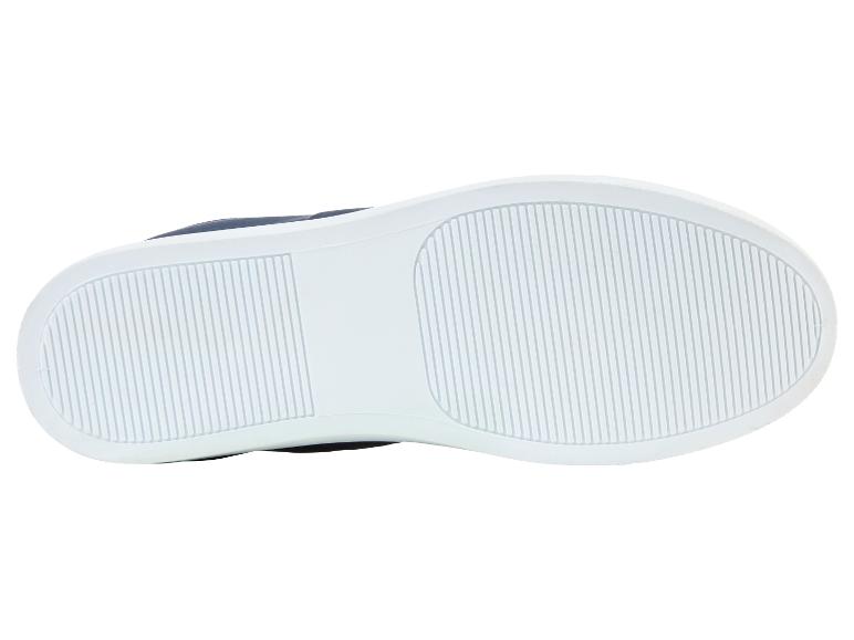 Białe podeszwy butów sportowych z granatową cholewką.