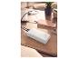 Biały power bank ładujący laptopa i smartfon na drewnianym stole.