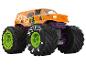 Pomarańczowy monster truck z zielonymi felgami i fioletowym zawieszeniem, oznaczony 'JESTER'.