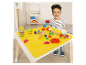 Małe dziecko bawi się plasteliną Play-Doh przy stole z wbudowaną matą do zabawy.