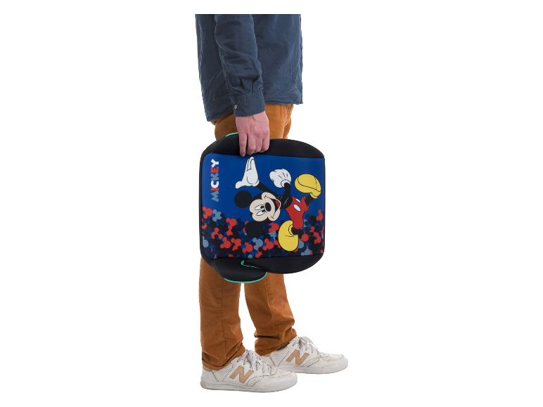 Osoba trzyma niebieskie siedzisko podwyższające Mickey Mouse z kolorowym wzorem.