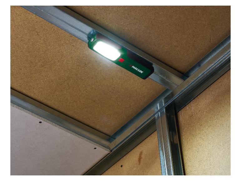 Lampa robocza Parkside przymocowana do metalowej ramy w niedokończonym pomieszczeniu.