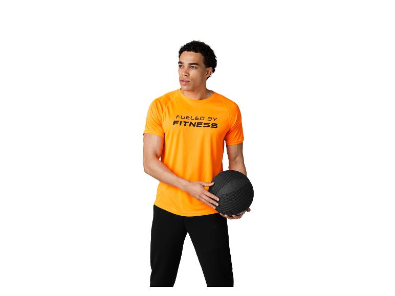 Mężczyzna w pomarańczowej koszulce „FUELED BY FITNESS” z czarną piłką lekarską.