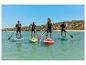 Osoby uprawiające paddleboarding na deskach Aqua Marina na morzu.