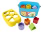 Sorter kształtów Fisher-Price z niebieskim wiadrem, żółtą pokrywką i kolorowymi kształtami.