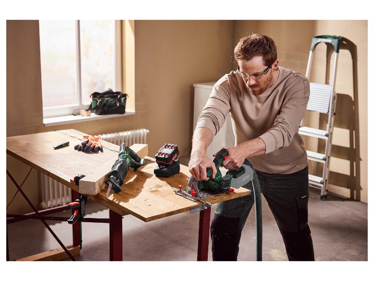 Mężczyzna tnie drewnianą deskę piłą tarczową, nosząc okulary ochronne.