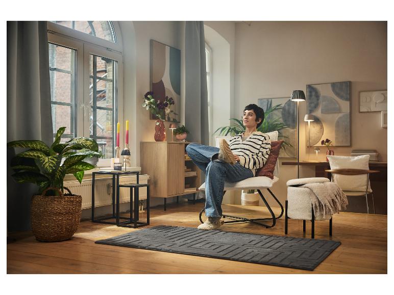 Kobieta relaksuje się w fotelu w przytulnym salonie.