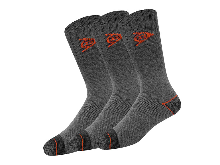 Trzy pary szarych skarpet z pomarańczowym logo.