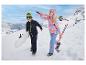 Dwoje dzieci w strojach zimowych z nartami i deską snowboardową w śnieżnym krajobrazie.