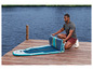 Mężczyzna składa dmuchany paddleboard na pomoście.