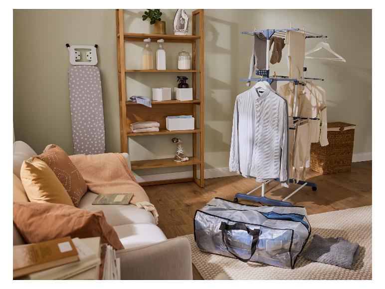 Pralnia z suszarką na pranie, deską do prasowania i drewnianą półką.