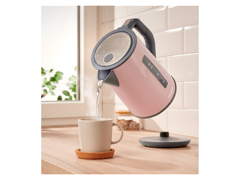 Różowy czajnik SilverCrest wlewa wodę do kubka.