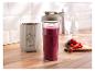 Blender do smoothie SilverCrest z butelką pełną owocowego smoothie i świeżymi owocami na drewnianej desce.