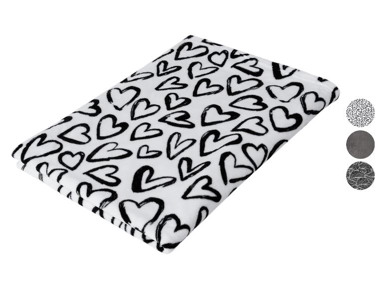 Biały koc w czarne serca z trzema okrągłymi próbkami wzorów.