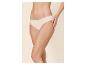 Kobieta w cielistych majtkach, z jedną ręką na udzie.