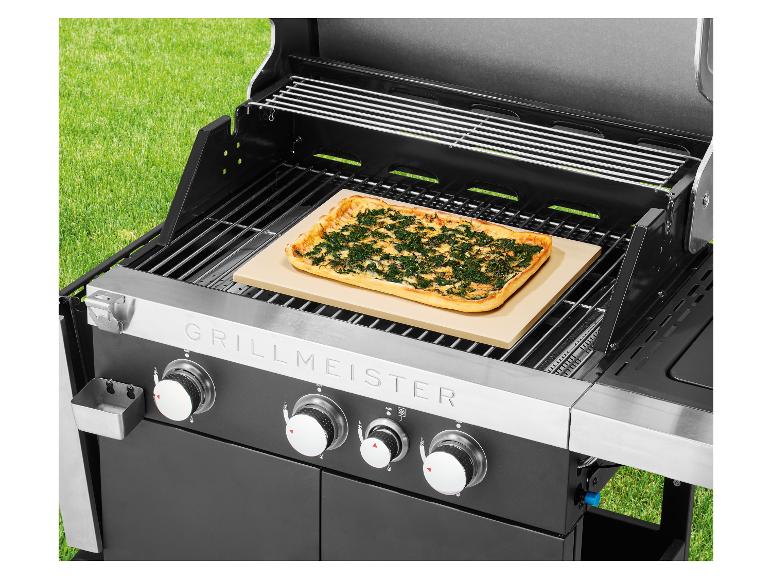 Grill z pizzą na kamieniu do pieczenia, na zewnątrz na trawie