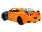 Pomarańczowy model samochodu Nissan GT-R z tylnym spojlerem.
