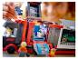 Dziecko bawi się ciężarówką wyścigową LEGO, z minifigurkami i samochodem wyścigowym.