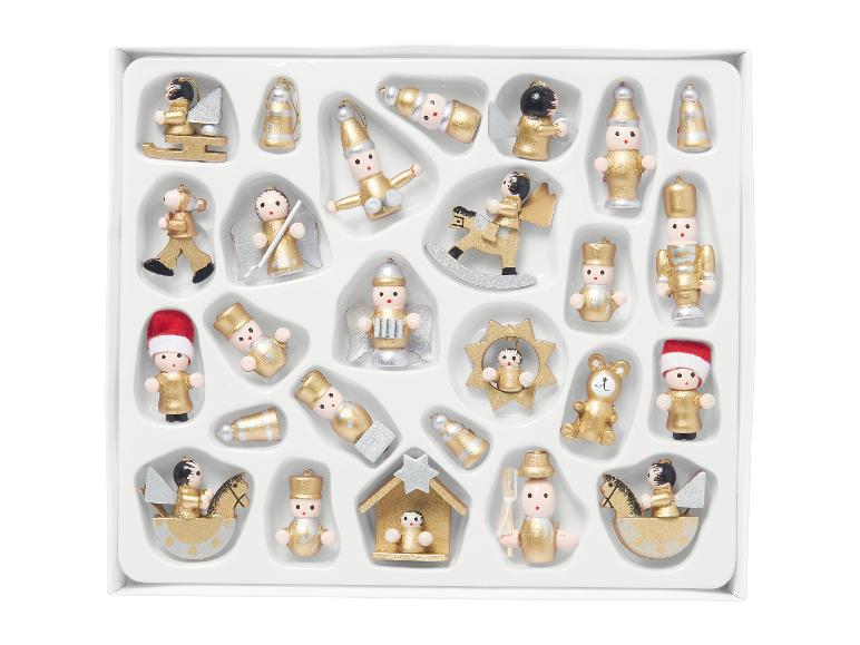 Asortyment złotych i srebrnych drewnianych ozdób świątecznych w białym pudełku.