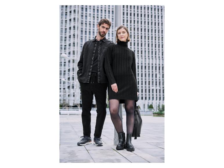 Para w czarnych, stylowych ubraniach na tle nowoczesnych budynków.