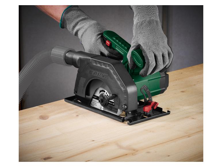 Osoba w rękawiczkach używa mini pilarki tarczowej Parkside na drewnianej powierzchni.