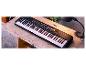 Czarne pianino Yamaha PSR-E363 z 61 klawiszami na drewnianym stole.