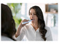Kobieta myje zęby elektryczną szczoteczką do zębów Oral-B.