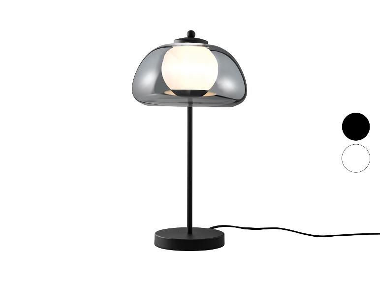 Lampa stołowa z przydymionym szklanym kloszem i czarną podstawą, z opcjami kolorystycznymi.