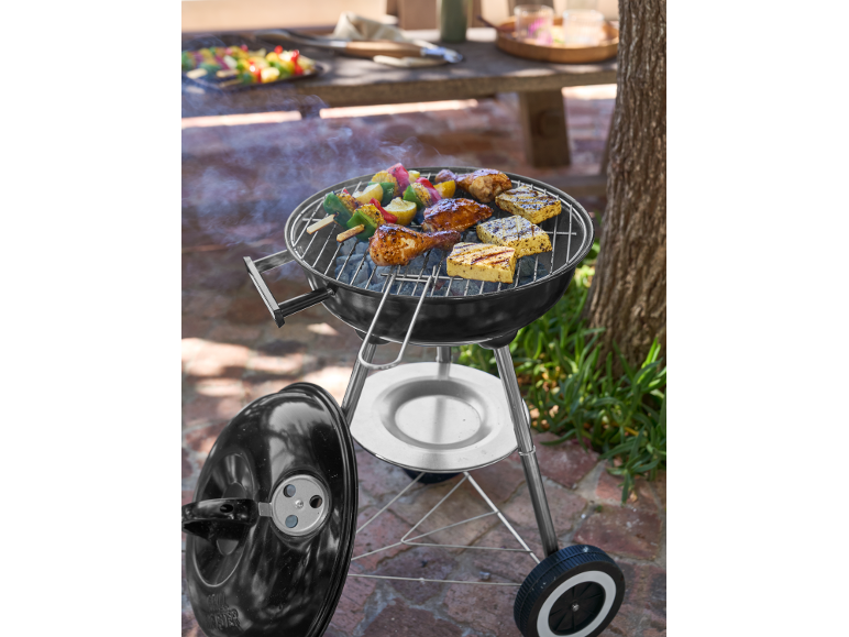 Grill węglowy z kurczakiem, halloumi i szaszłykami warzywnymi gotującymi się na zewnątrz.