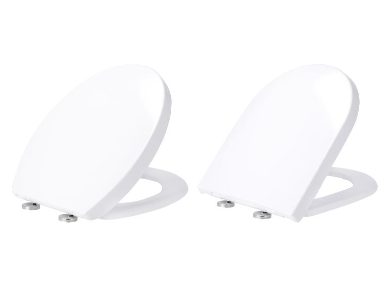 Dwie białe, owalne deski sedesowe na białym tle