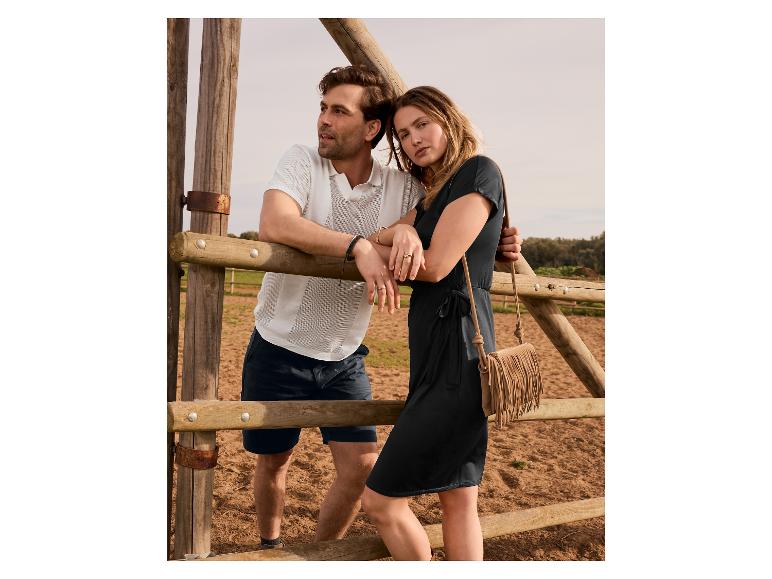 Luźna sukienka i polo w pobliżu drewnianego płotu.