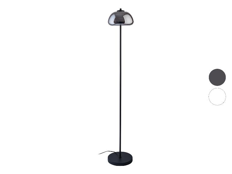 Czarna stojąca lampa podłogowa z kloszem z ciemnego szkła.