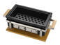 Czarny ceramiczny grill z drewnianymi uchwytami na drewnianej desce.