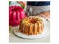 Ciasto bundt polewane lukrem, ozdobione pistacjami i skórką z cytryny.