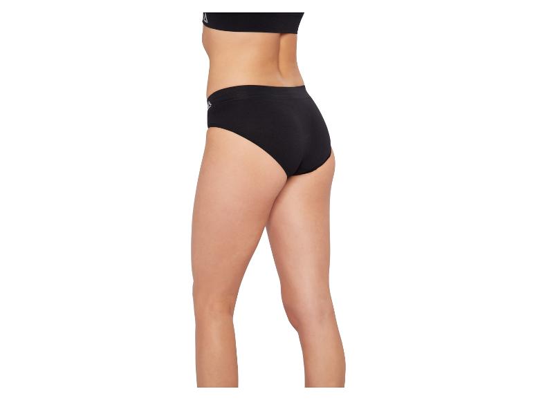 Kobieta w czarnych majtkach i czarnym biustonoszu sportowym, widok z boku.