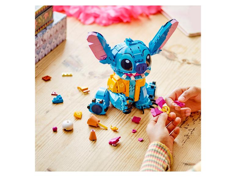 Dziecko składa zabawkę konstrukcyjną Stitch z rozrzuconymi elementami.