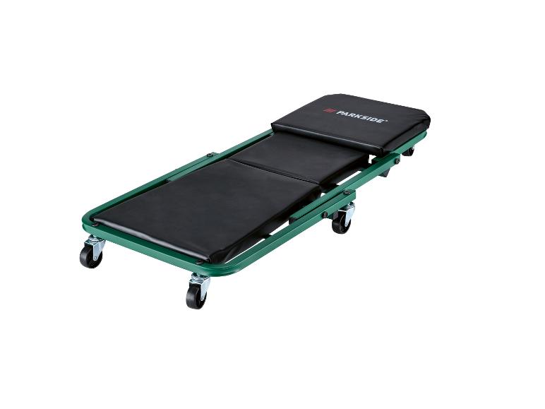 Zielony leżak mechanika z czarnymi wyściełanymi poduszkami i kółkami