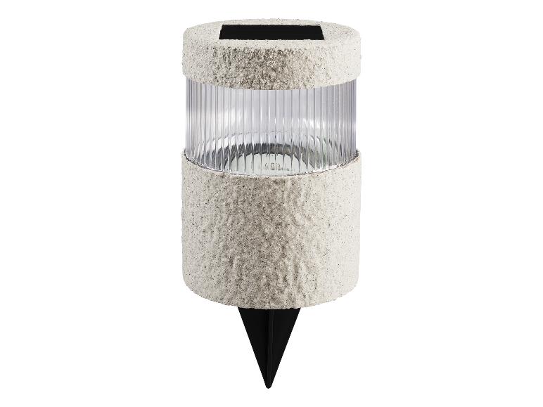 Lampa solarna ogrodowa z teksturowaną szarą obudową i żebrowanym przezroczystym kloszem.